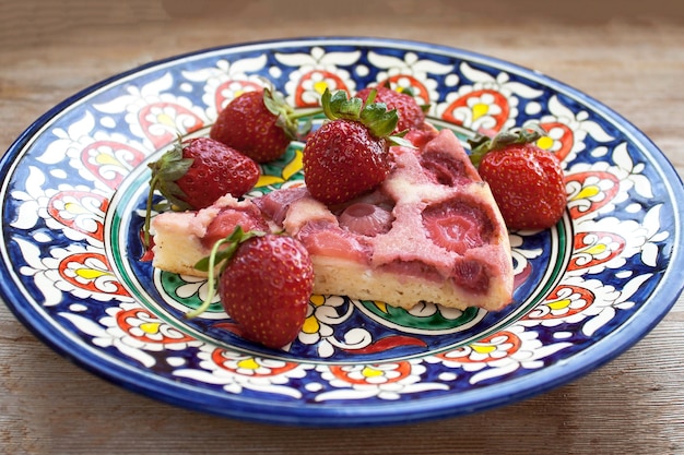 Slice of strawberry pie on pink plate with strawberries