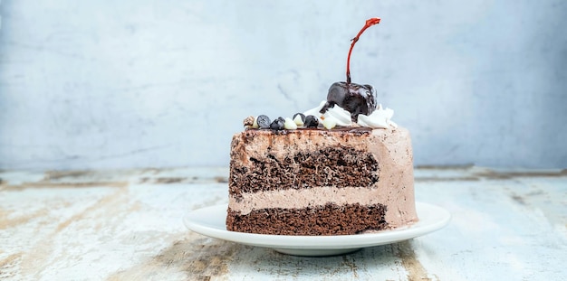 Slice of tasty homemade choccolate cake on the plate on wooden background