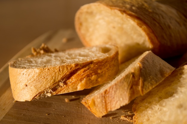 Sliced baguette on the wooden board.