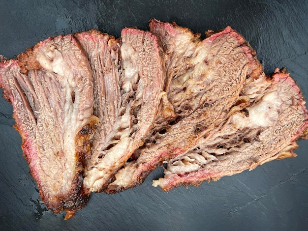 Sliced beef brisket on black slate board Directly above