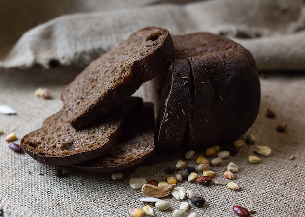 Sliced brown bread with grains on sackcloth