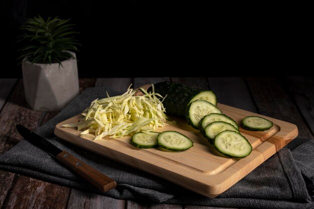 Sliced cabbage and cucumber lie on the table in the kitchen