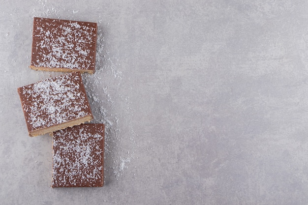 Sliced chocolate cake placed on stone table.