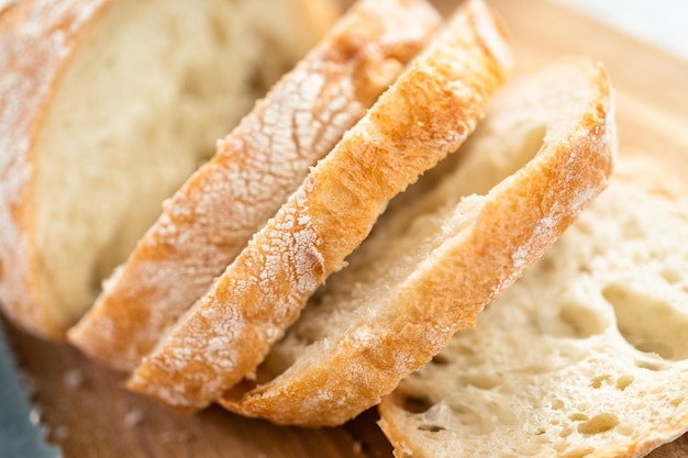 Sliced fresh loaf of bread on a wooden cutting board.