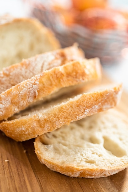 Sliced fresh loaf of bread on a wooden cutting board.