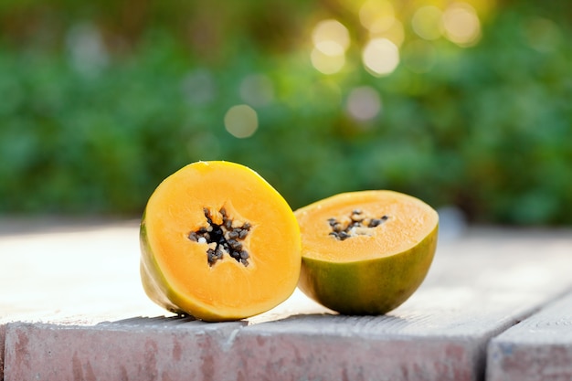 Sliced fresh papaya on a wooden table on the street.