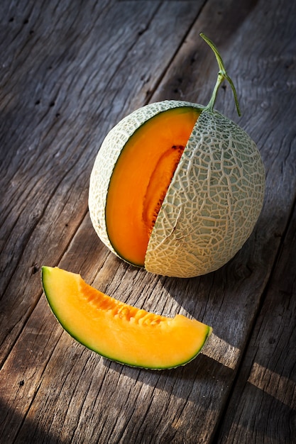 Sliced fresh sweet melon on wooden board. Orange texture and juice taste of fruit. 