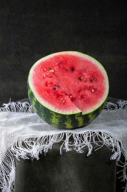 Sliced fresh watermelon on a round table on a dark background