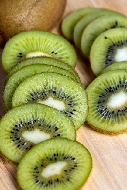 Sliced green kiwi fruit on a wooden board