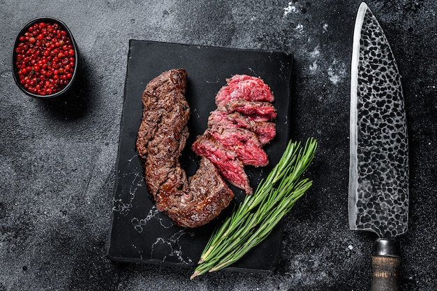 Sliced grilled Onglet Hanging Tender steak on a marble board