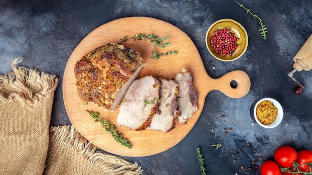 Sliced grilled pork barbecue meat on wooden cutting board