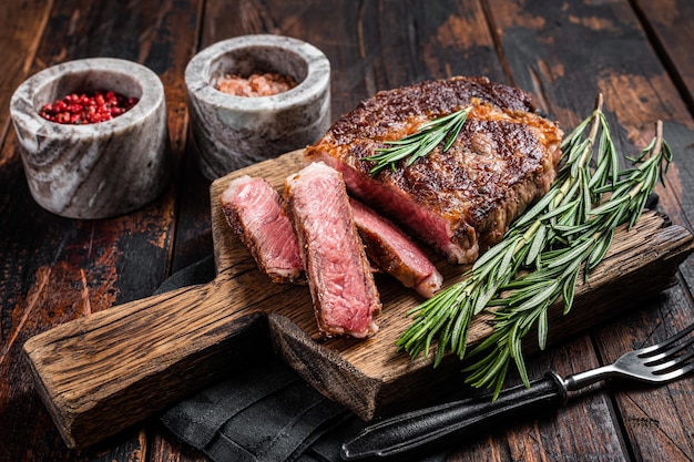 Sliced and Grilled rib eye steak ribeye beef marbled meat on a wooden board Wooden background top view