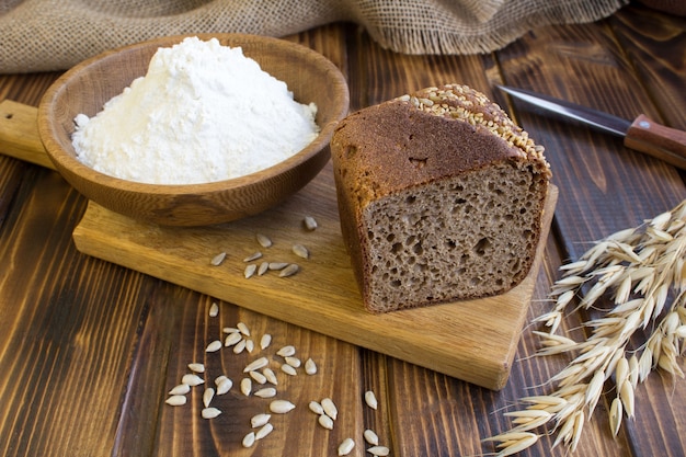 Sliced homemade bread on the cutting board on the brown wooden background