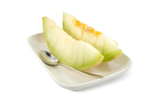 Sliced of juicy Japanese gold melon on white serving plate clipping path