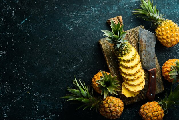 Sliced juicy pineapples Ripe baby pineapple Tropical fruits Top view Free space for text