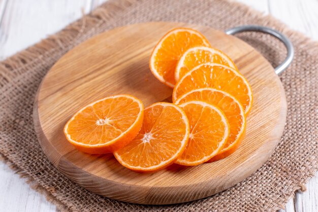 Sliced juicy ripe tangerines on an wooden chopping Board