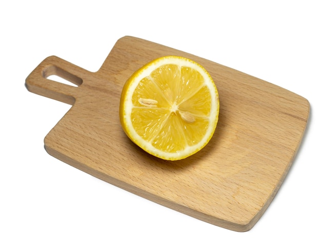 A sliced lemon on a small cutting board on a white background Citrus on the table Bright background Healthy fortified food for a diet