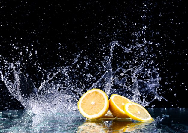 Sliced lemon in the water on black surface