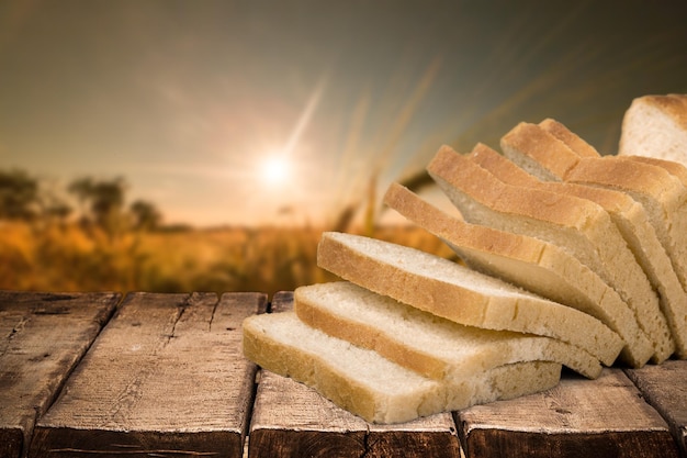 Sliced loaf of bread on wooden table on background