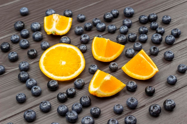 Sliced orange and blueberry Dark wooden background