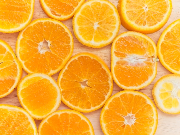 Sliced oranges on wooden chopping board arranged around of frame