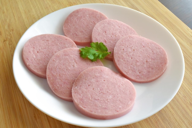 Sliced parizaki greek sausage with coriander on a white plate