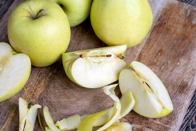 Sliced and peeled green apple on a wooden board