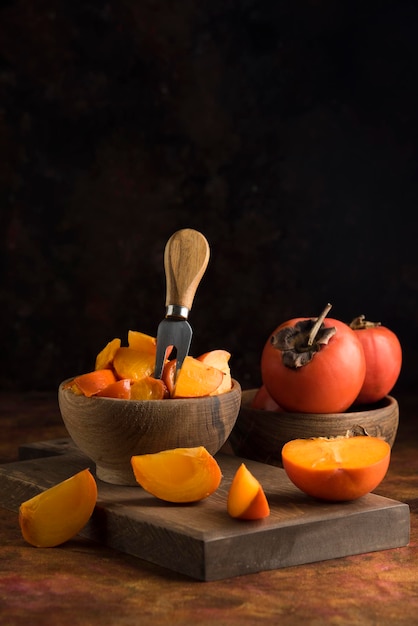 Sliced persimmons on wood cutting board