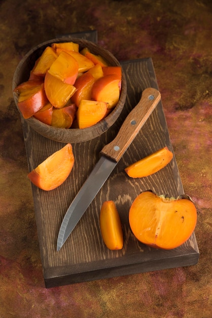 Sliced persimmons on wood cutting board