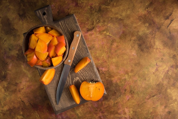 Sliced persimmons on wood cutting board