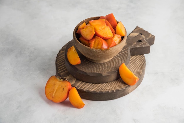 Sliced persimmons on wood cutting board