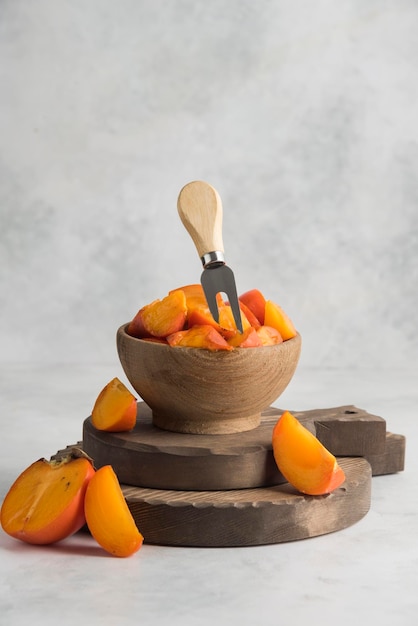 Sliced persimmons on wood cutting board