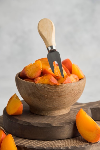 Sliced persimmons on wood cutting board