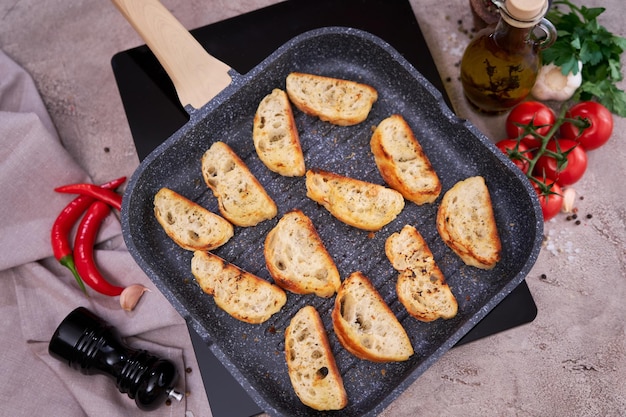 Sliced pieces of baguette on grill frying pan