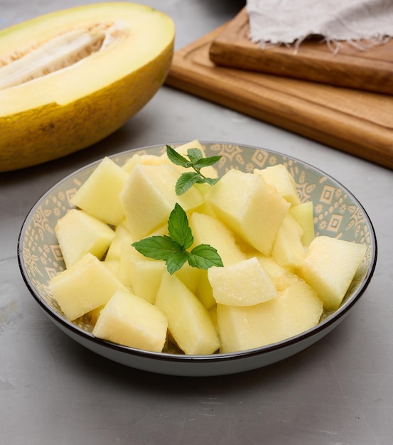 Sliced pieces of melon in a round gray plate on the table