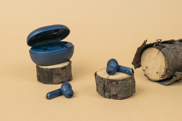 Sliced pieces of wood and wireless headphones on a beige background