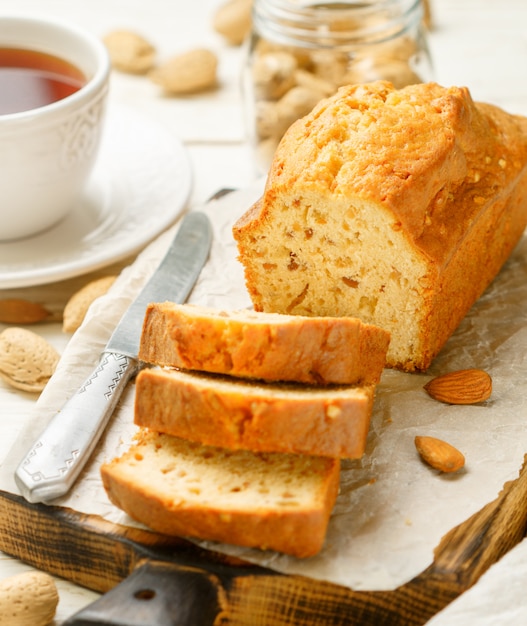 Sliced pound cake with almonds on the cutting Board. Homemade cake with nuts and honey