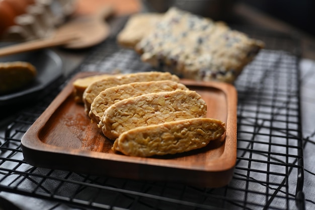 Sliced raw tempeh on wooden plate Tempeh or Tempe made from fermented soybeans vegetarian food