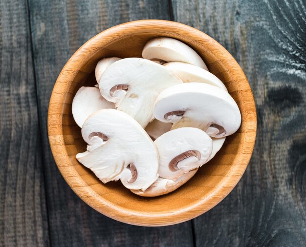 Sliced raw white champignons preparing for cooking