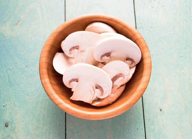 Sliced raw white champignons preparing for cooking