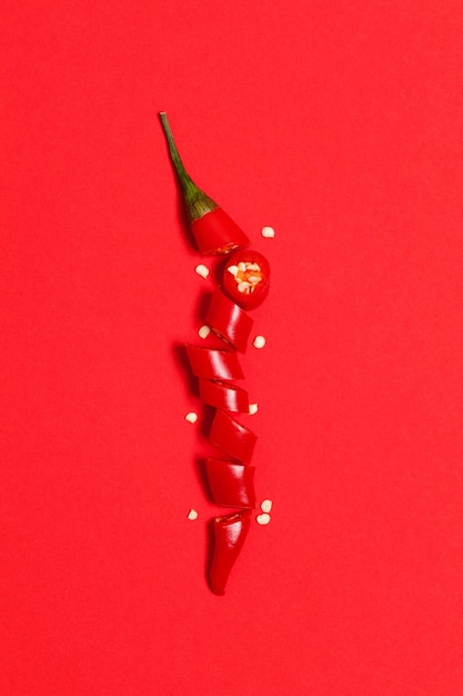 Sliced red chili pepper arranged on a bright red background