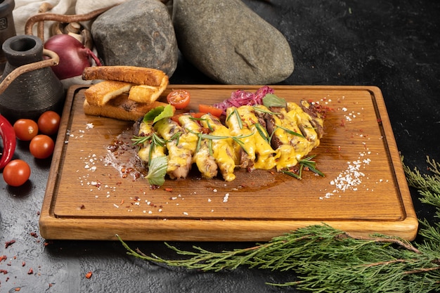 Sliced rib eye steak with cheese sauce, vegetables and wheat croutons