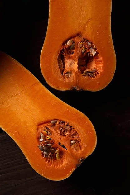 Sliced ripe orange pumpkin close up wooden background