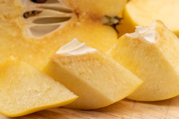 Sliced ripe yellow quince on a cutting board pieces of ripe quince cut into slices on the table