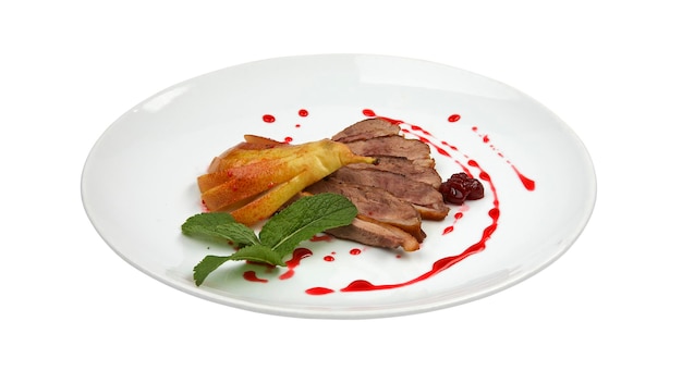 Sliced roasted duck fillet with pear and berry sauce on white round plate