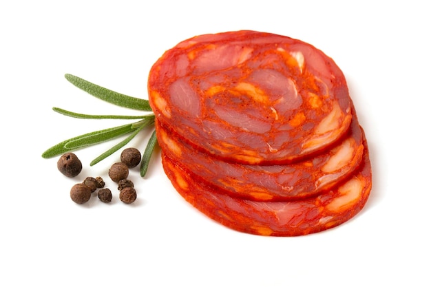 Sliced round pieces of rawcured Chorizo sausage with rosemary leaf on a white background