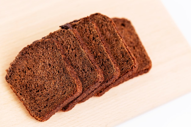 Sliced Russian Borodino brown bread on a white background. Healthy eating and traditions. Close-up. Top view.