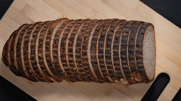 Sliced rye bread on a board on wooden table