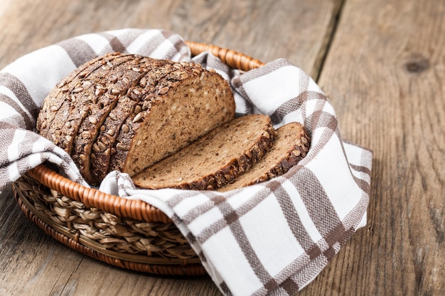 Sliced rye bread with seeds in the basket on a wooden table