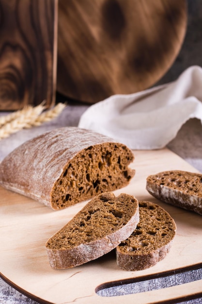 Sliced rye ciabatta on a cutting board on the table Homemade baking Vertical view